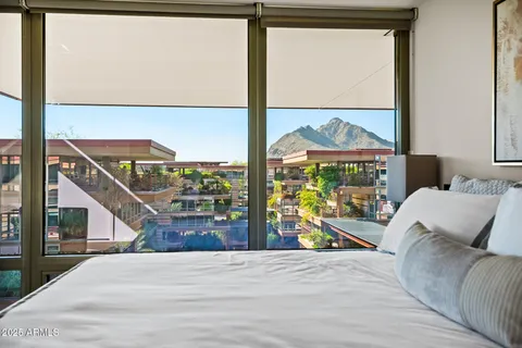 a bedroom with a bed and large window