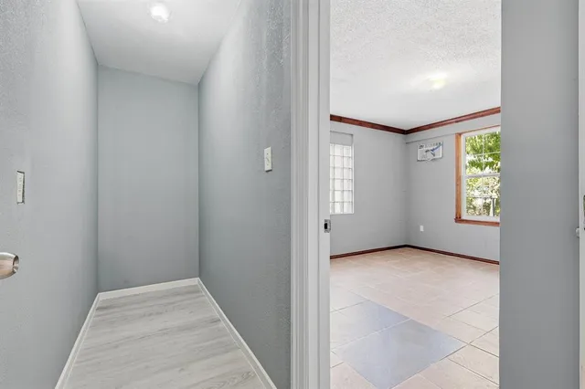 a view of an empty room with window and stairs