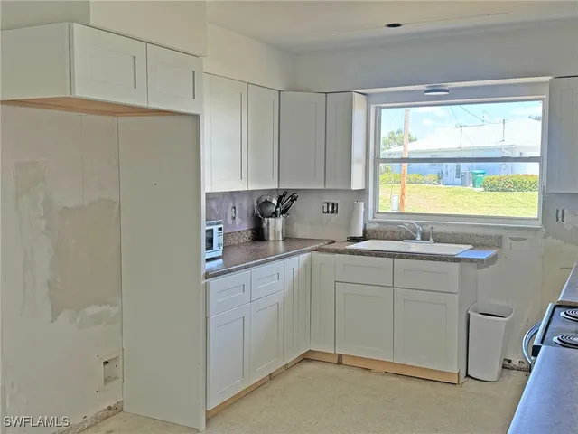 a kitchen with stainless steel appliances white cabinets and a granite counter top