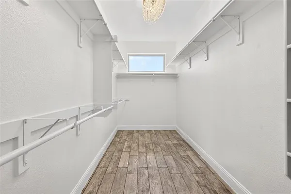a view of a hallway with wooden floors and a window