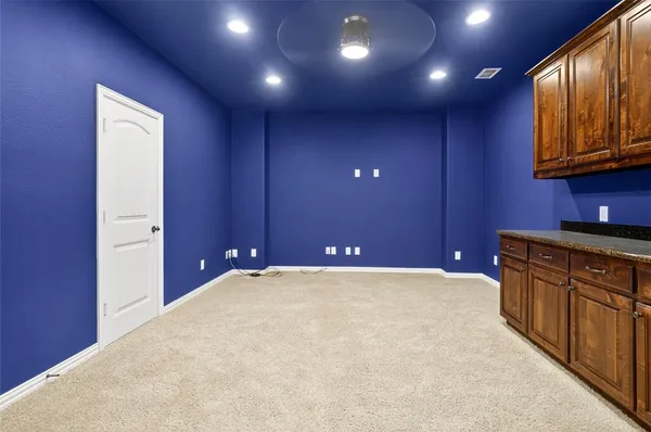 a view of an empty room with wooden floor and cabinet