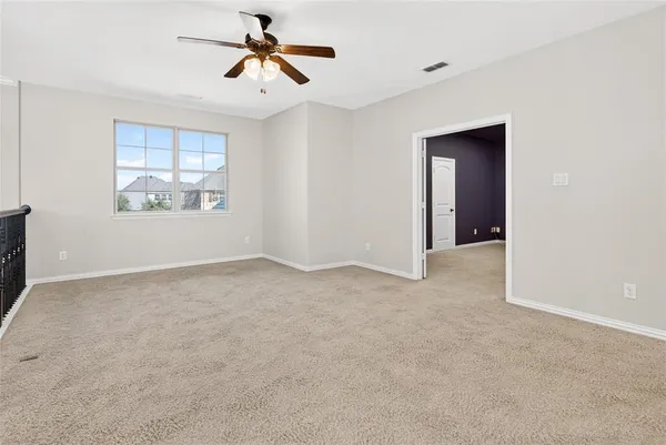 a view of a room with a ceiling fan and window