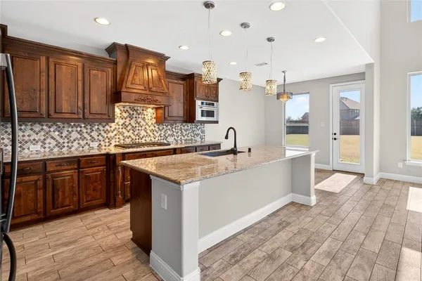 a kitchen with granite countertop a sink and cabinets