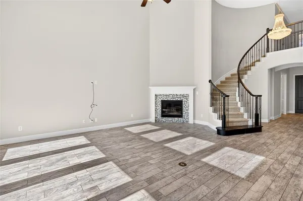a view of an empty room with wooden floor and a fireplace