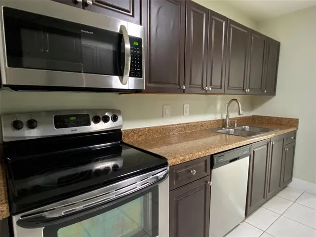 a kitchen with granite countertop a stove and a microwave