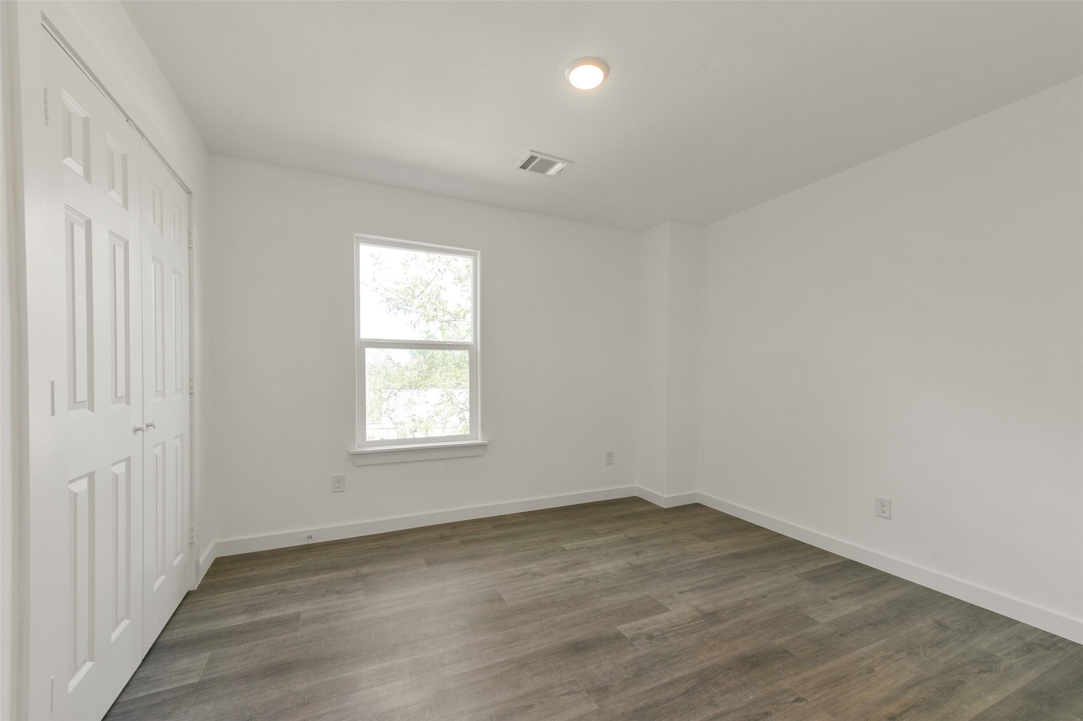 8713 Southwark Street, Unit B Houston, TX 77028 - Photo 13 of 17 an empty room with wooden floor and windows