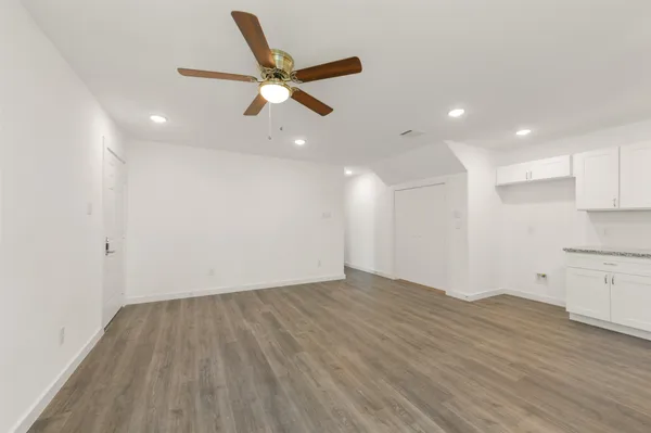 a view of empty room with wooden floor