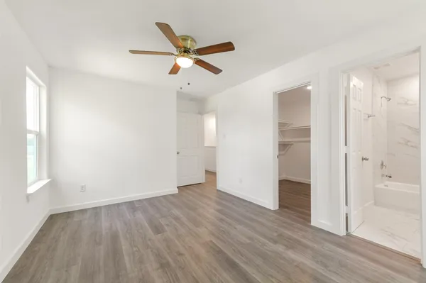 a view of empty room with wooden floor and window
