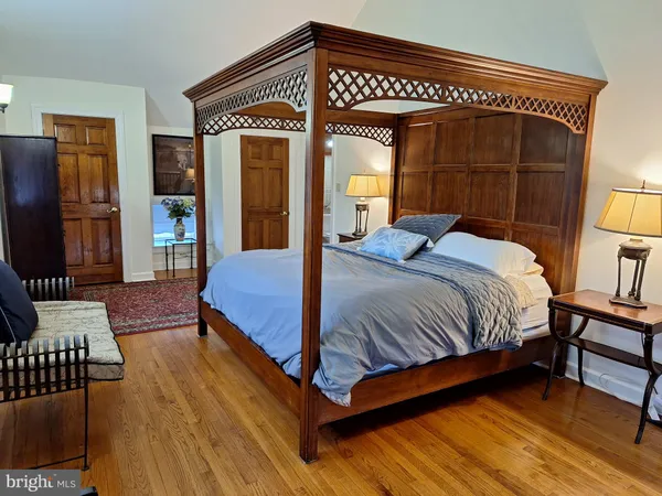 a bedroom with a bed a dresser and chair