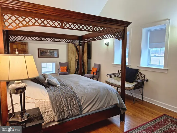 a bedroom with a bed and a dresser next to a window
