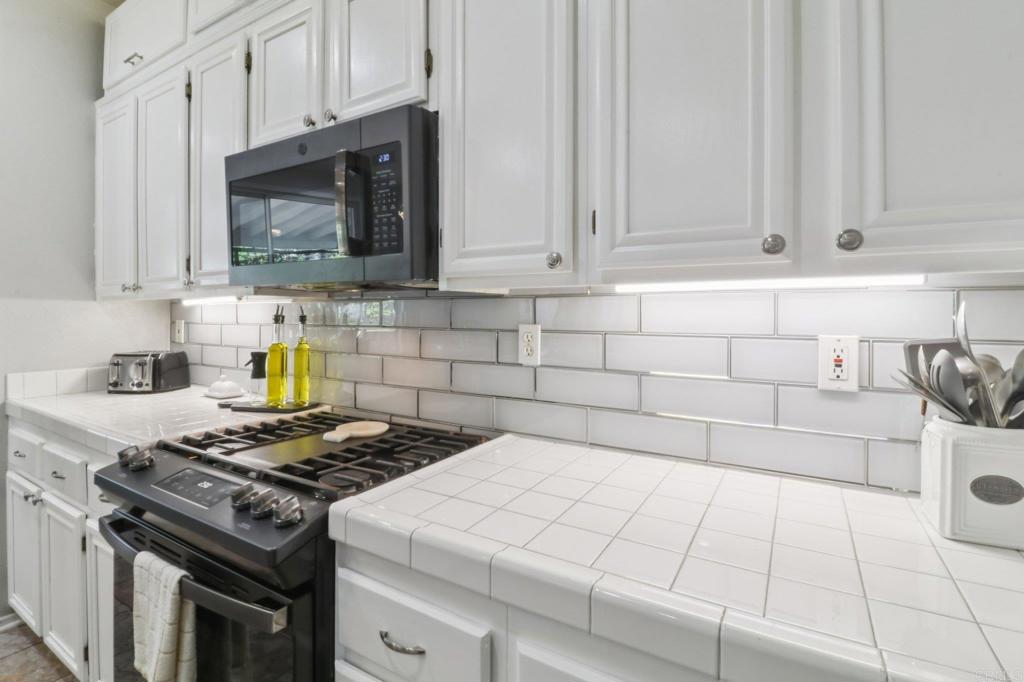 232 Manzanilla Way Oceanside, CA 92057 - Photo 17 of 35 a kitchen with stainless steel appliances granite countertop a stove a white cabinet and a granite counter tops