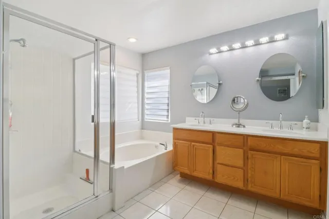 a spacious bathroom with a double vanity sink mirror and bathtub