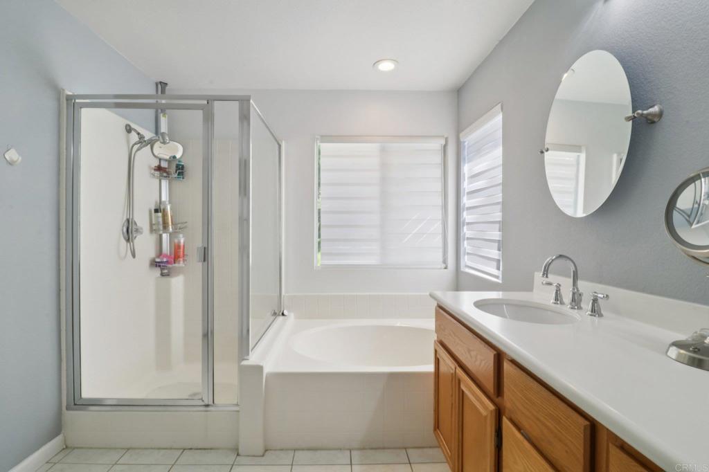 232 Manzanilla Way Oceanside, CA 92057 - Photo 25 of 35 a bathroom with a sink a mirror a bathtub and shower