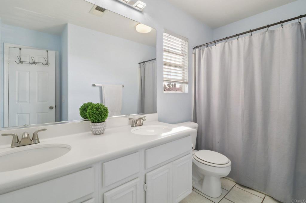 232 Manzanilla Way Oceanside, CA 92057 - Photo 32 of 35 a bathroom with a granite countertop sink and a mirror