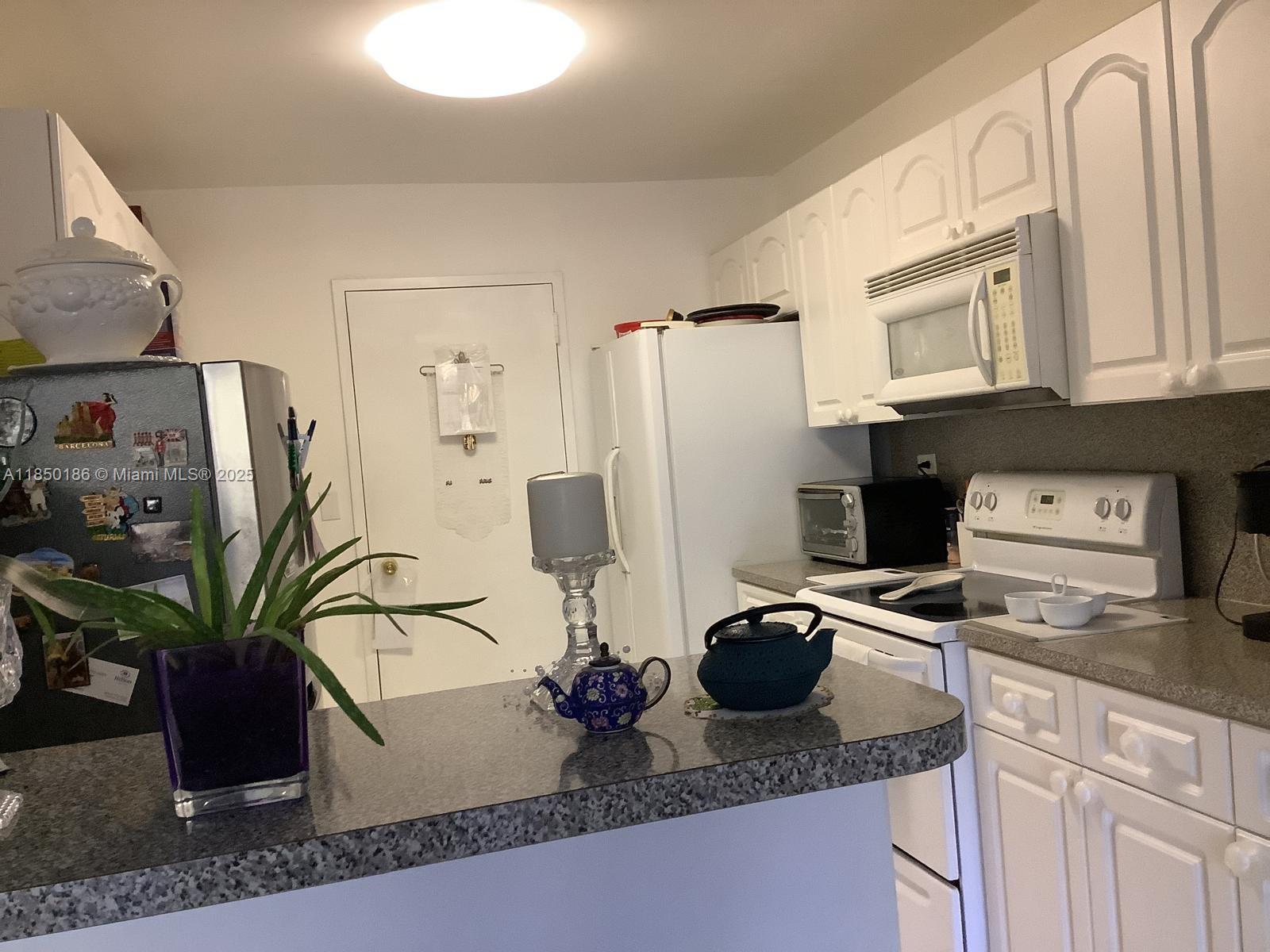 800 Northeast 195th Street, Unit 215 Miami, FL 33179 - Photo 11 of 11 a kitchen with stainless steel appliances granite countertop a refrigerator a stove and a sink