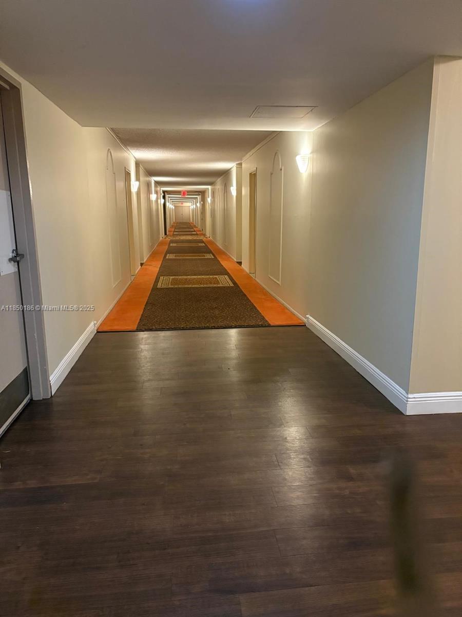 800 Northeast 195th Street, Unit 215 Miami, FL 33179 - Photo 6 of 11 an empty room with wooden floor