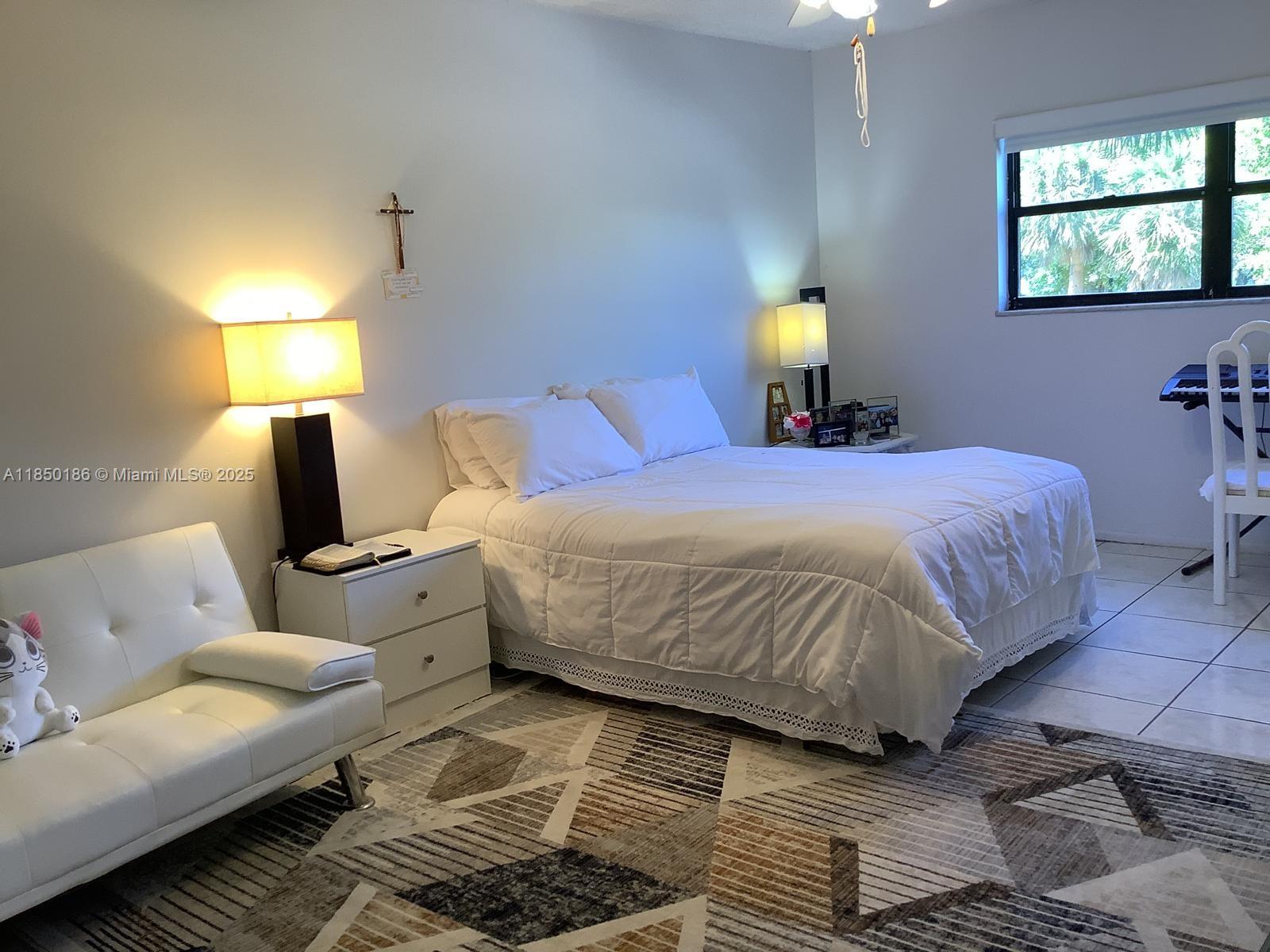 800 Northeast 195th Street, Unit 215 Miami, FL 33179 - Photo 8 of 11 a bedroom with a bed and wooden floor