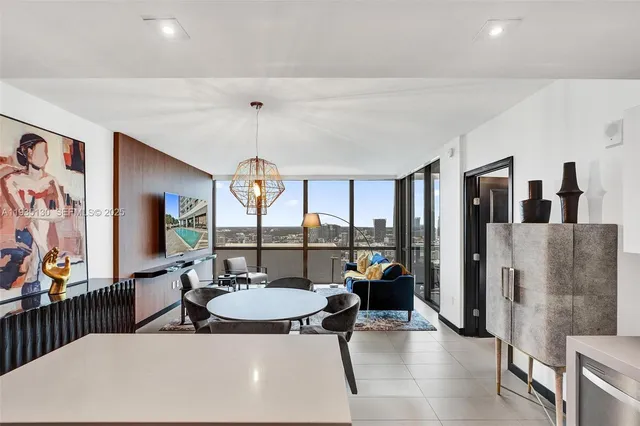 a living room with furniture a flat screen tv and a large window