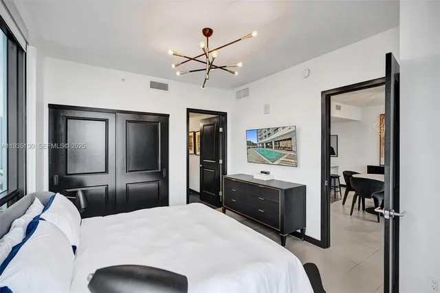 a bedroom with a bed and a chandelier