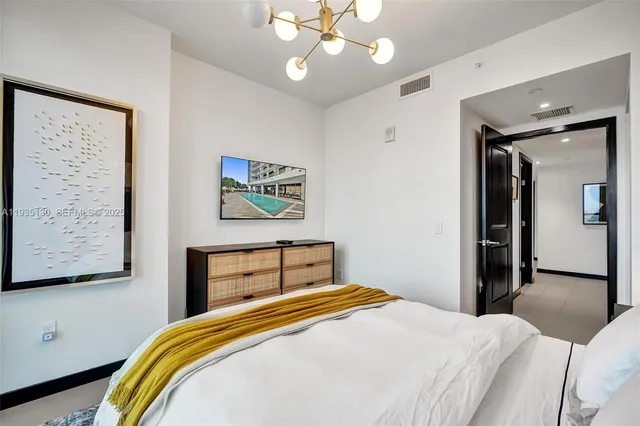 a bedroom with a bed and a painting on the wall