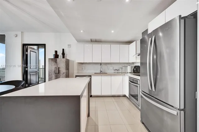 a kitchen with white cabinets and stainless steel appliances
