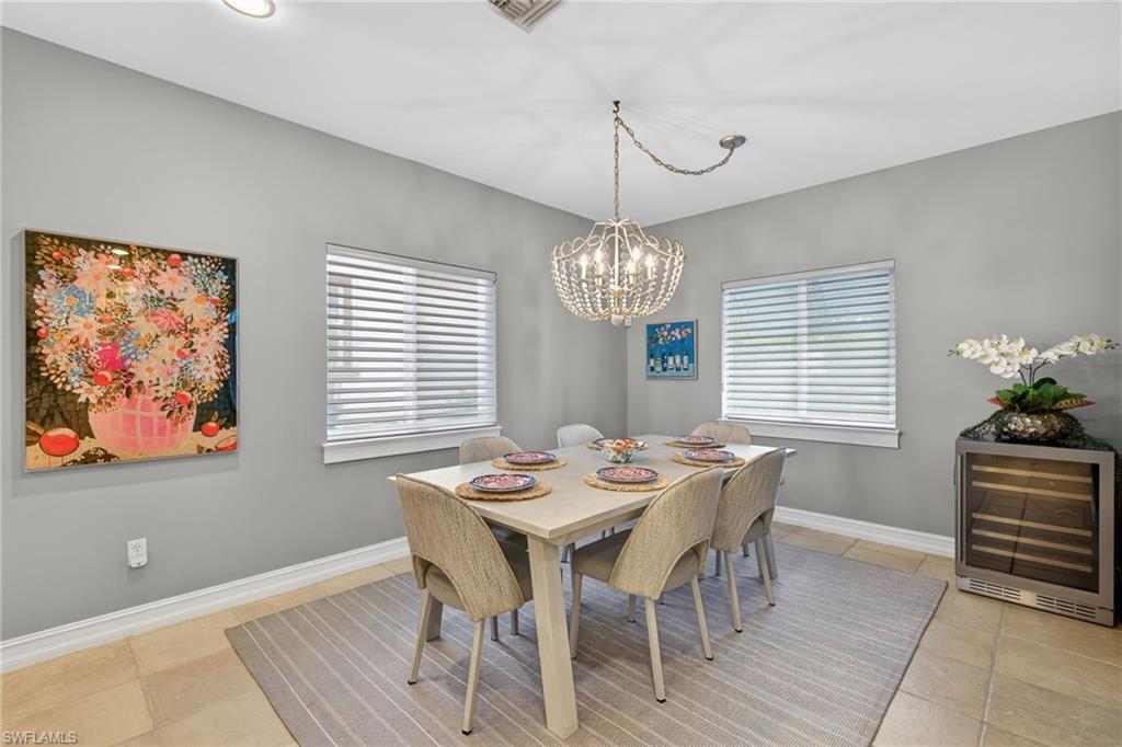 740 5th Avenue North Naples, FL 34102 - Photo 14 of 43 a view of a dining room with furniture a chandelier and wooden floor