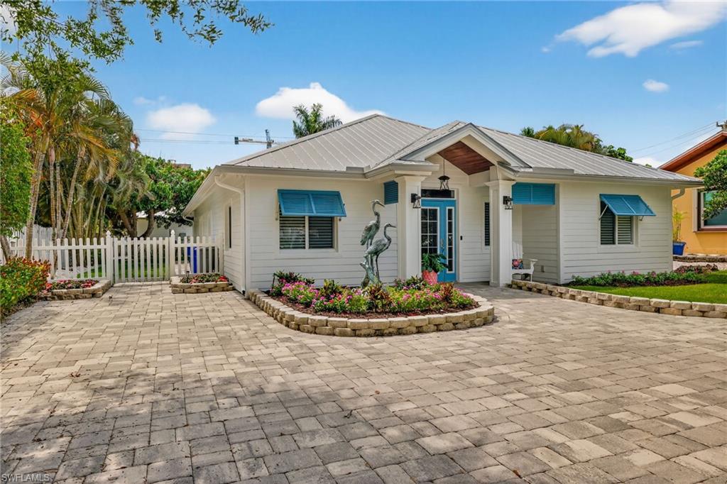 740 5th Avenue North Naples, FL 34102 - Photo 2 of 43 a front view of a house with a porch