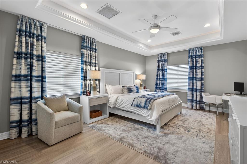 740 5th Avenue North Naples, FL 34102 - Photo 22 of 43 a spacious bedroom with a bed and a couch