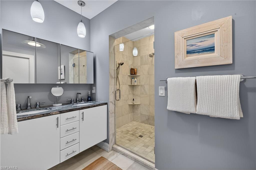 740 5th Avenue North Naples, FL 34102 - Photo 26 of 43 a spacious bathroom with a double vanity sink a mirror and a shower