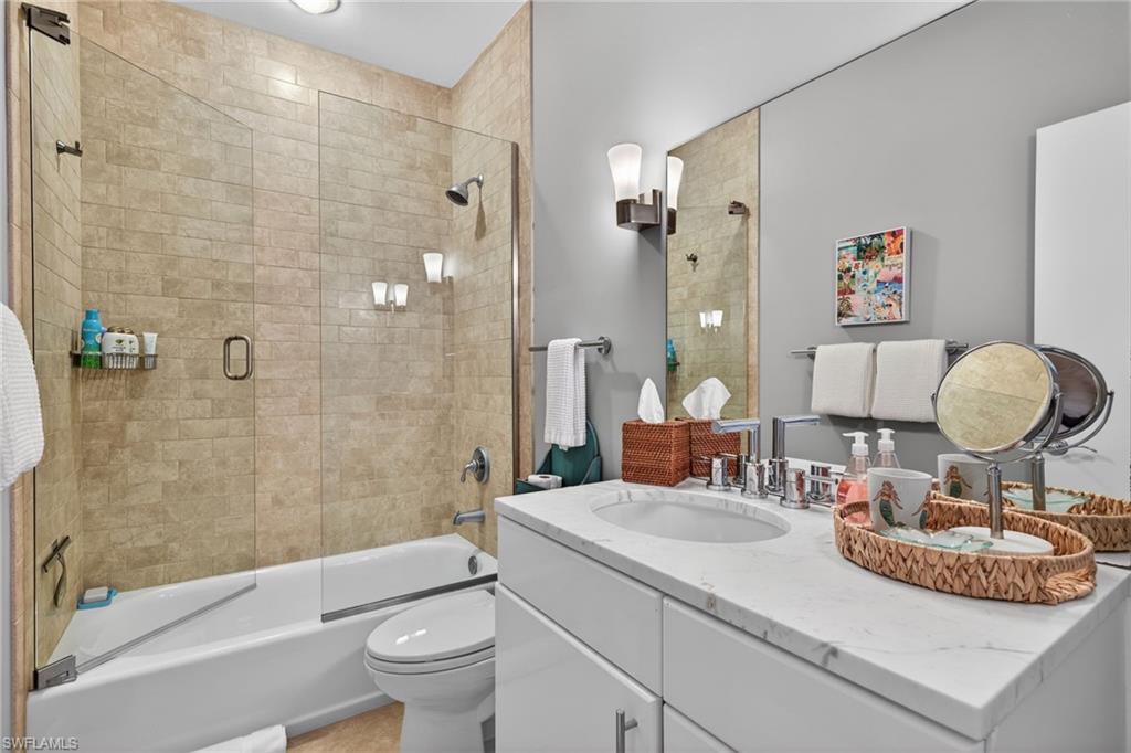 740 5th Avenue North Naples, FL 34102 - Photo 28 of 43 a bathroom with a granite countertop sink a toilet and shower
