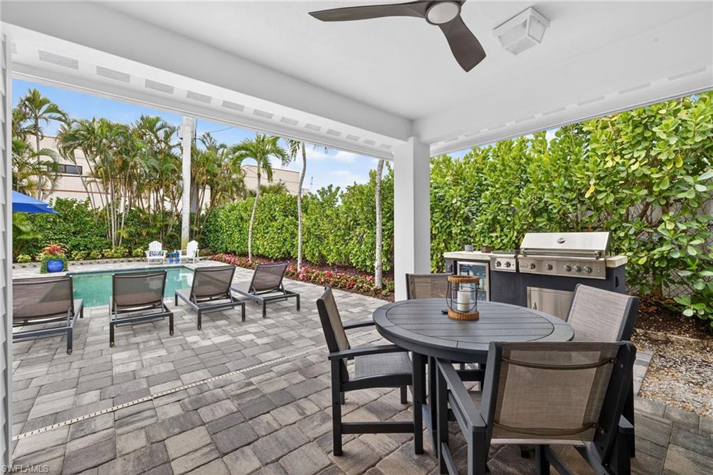 740 5th Avenue North Naples, FL 34102 - Photo 32 of 43 a view of a patio with a dining table and chairs