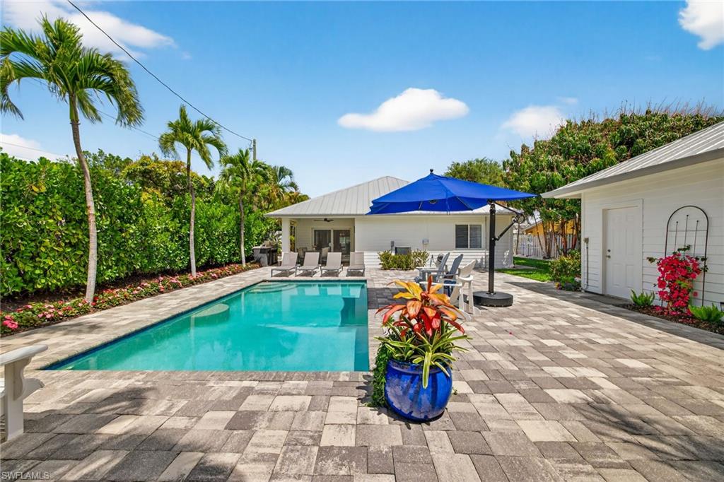 740 5th Avenue North Naples, FL 34102 - Photo 36 of 43 a patio with a table and chairs under an umbrella