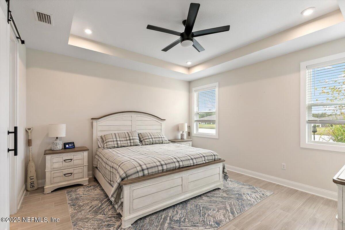 110 Fly Line Drive St. Johns, FL 32259 - Photo 14 of 65 a bedroom with a bed a window and a chandelier