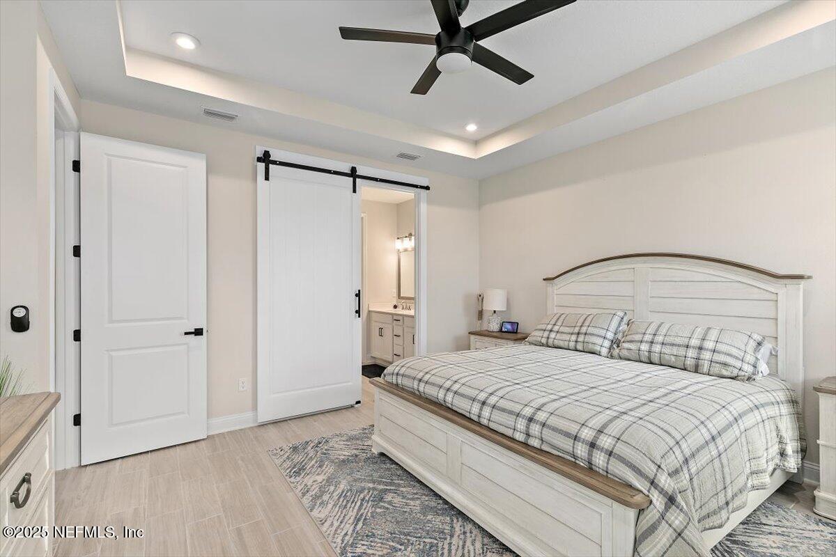 110 Fly Line Drive St. Johns, FL 32259 - Photo 15 of 65 a bedroom with a large bed and a chandelier