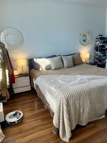 a bedroom with a bed and wooden floor