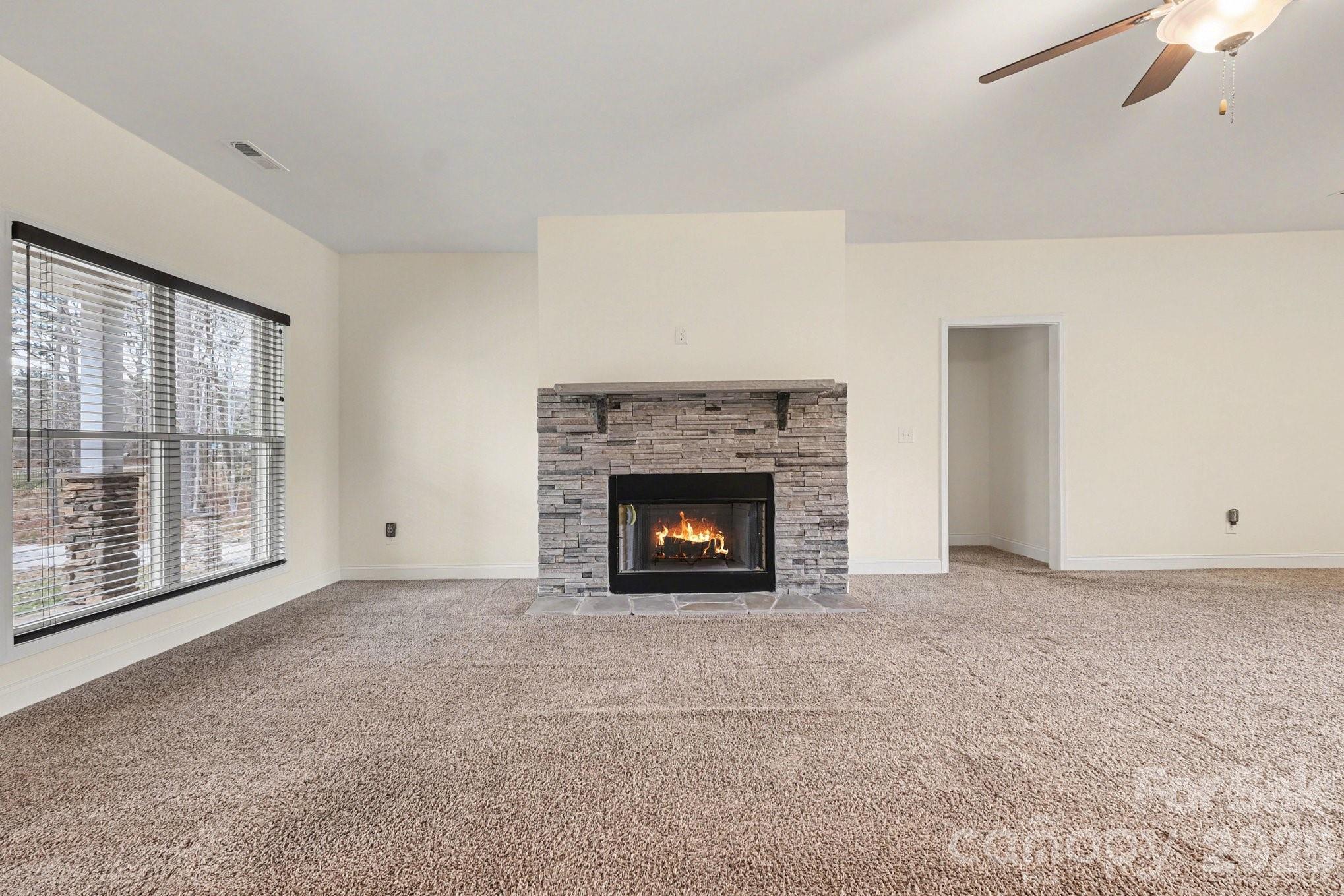 175 Cox Lake Road Stanley, NC 28164 - Photo 18 of 45 a view of an empty room with a window and fireplace