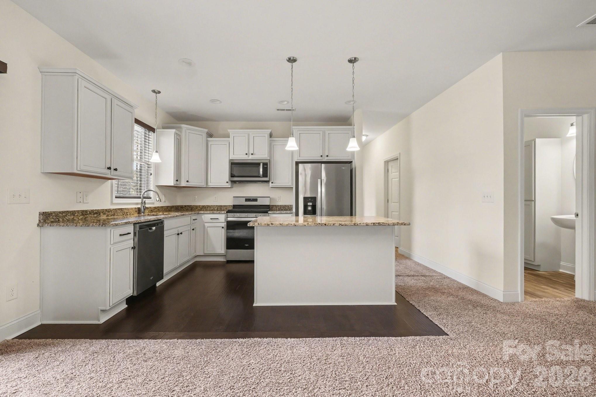 175 Cox Lake Road Stanley, NC 28164 - Photo 26 of 45 a kitchen with kitchen island a white counter top space cabinets and stainless steel appliances