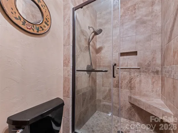a bathroom with a toilet and a shower