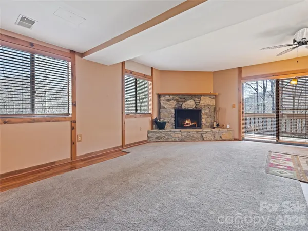 an empty room with fireplace and windows