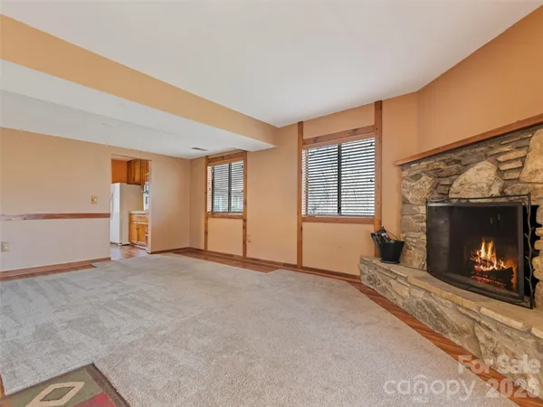 a view of an empty room with a fireplace and a window