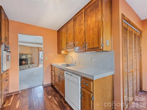 a kitchen with stainless steel appliances granite countertop a stove a sink and a refrigerator with wooden floor