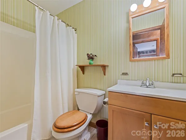 a bathroom with a granite countertop toilet sink and mirror