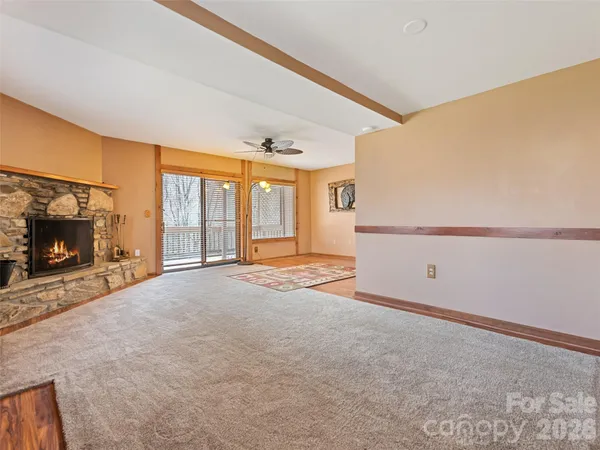 a view of an empty room with a fireplace and a window