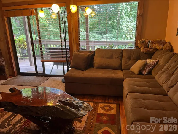 a living room with furniture and a floor to ceiling window