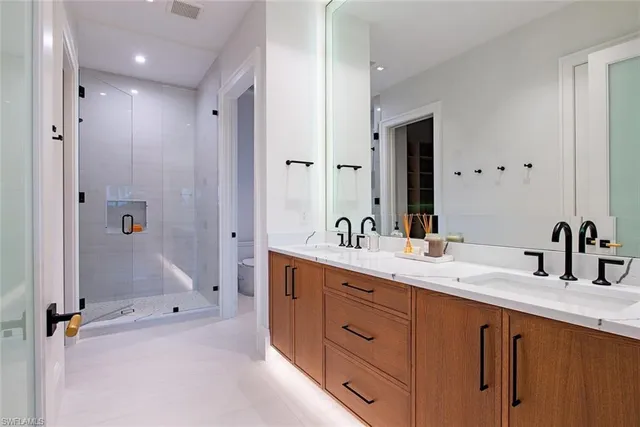 a bathroom with a double vanity sink mirror double and shower