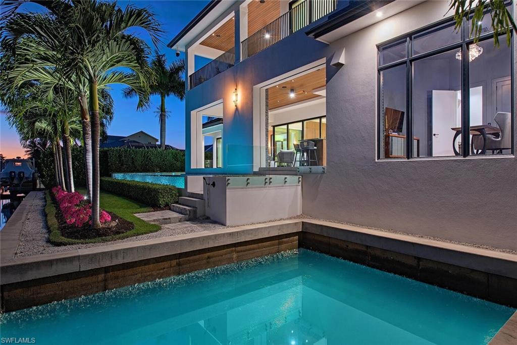 608 16th Avenue South Naples, FL 34102 - Photo 29 of 36 a front view of a house with swimming pool and porch