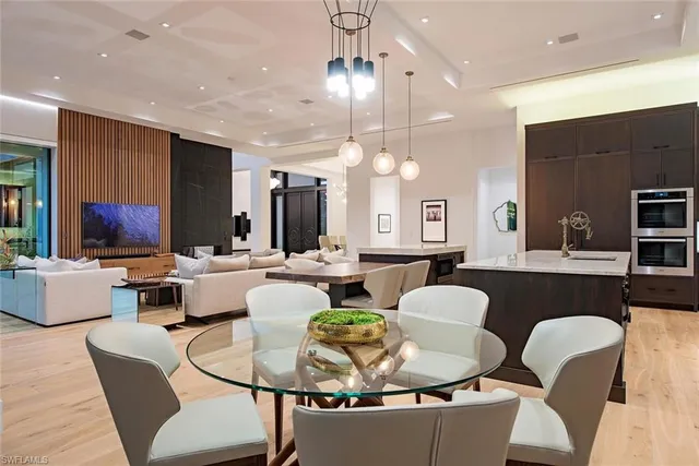a living room with furniture kitchen view and a chandelier