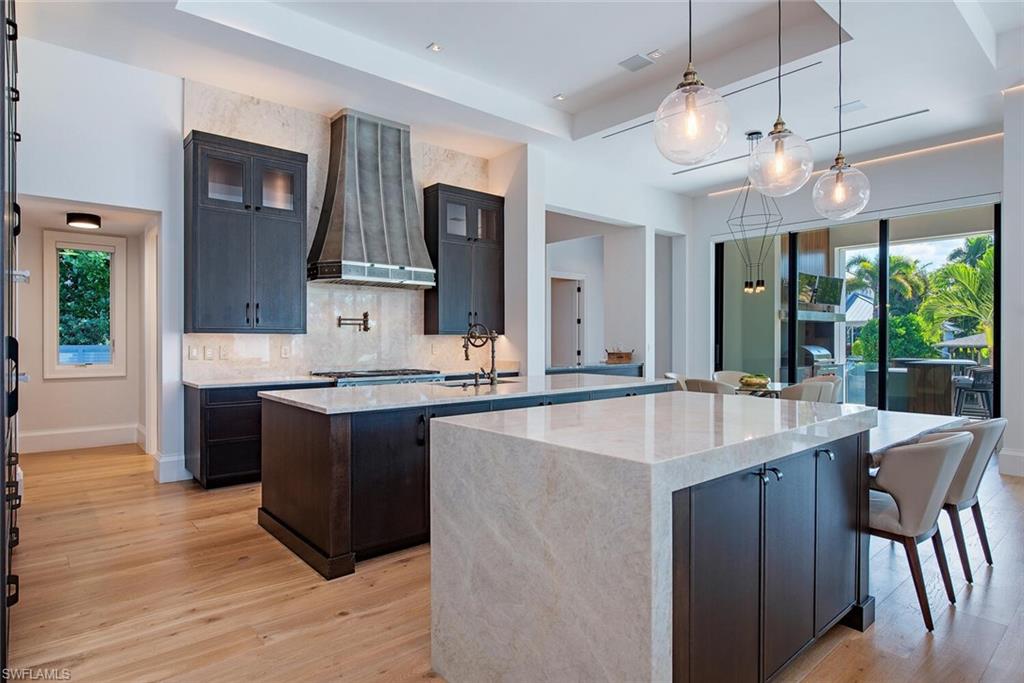 608 16th Avenue South Naples, FL 34102 - Photo 7 of 36 a kitchen with kitchen island granite countertop a sink and a stove