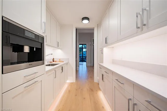 a kitchen with granite countertop white cabinets and white appliances