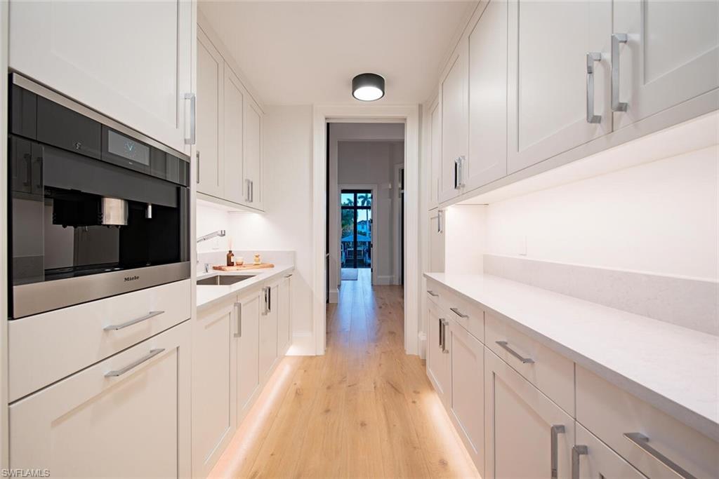 608 16th Avenue South Naples, FL 34102 - Photo 9 of 36 a kitchen with granite countertop white cabinets and white appliances